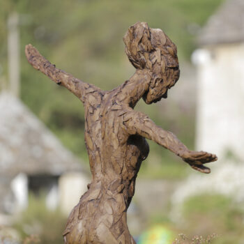 bronze sculpture of a woman holding her arms out